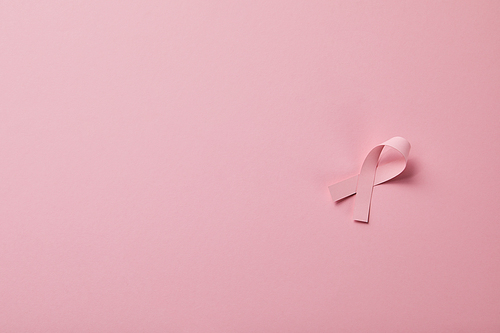 breast cancer ribbon on light pink background
