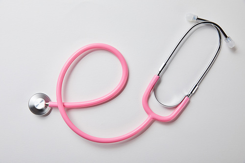 top view of pink stethoscope on white