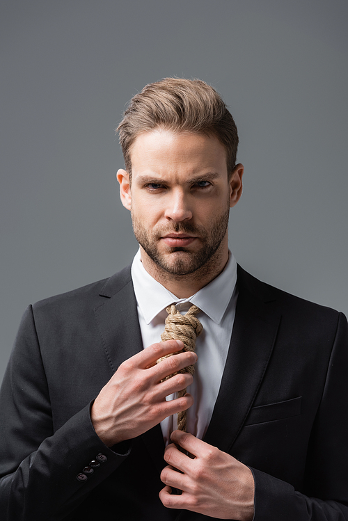 stressed businessman with rope on neck  isolated on grey