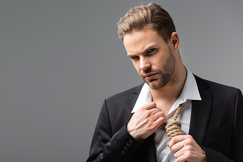 depressed businessman touching rope on neck while  isolated on grey