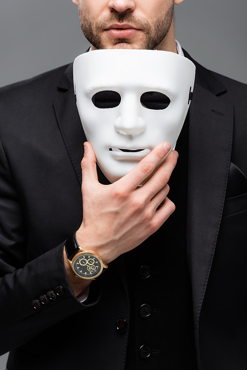 cropped view of corporate manager holding face mask isolated on grey