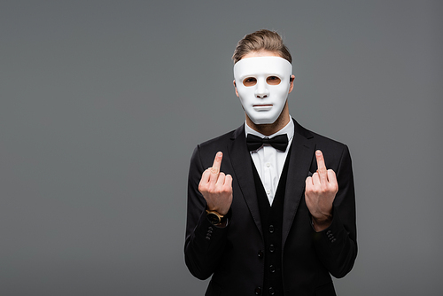 businessman showing middle fingers while wearing face mask isolated on grey