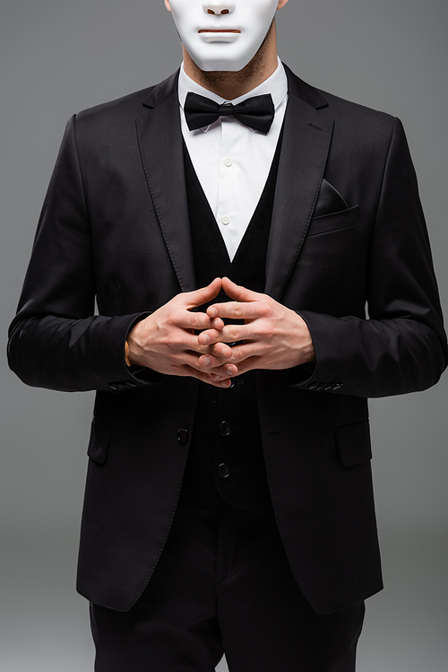 cropped view of businessman in face mask standing with joined fingers isolated on grey