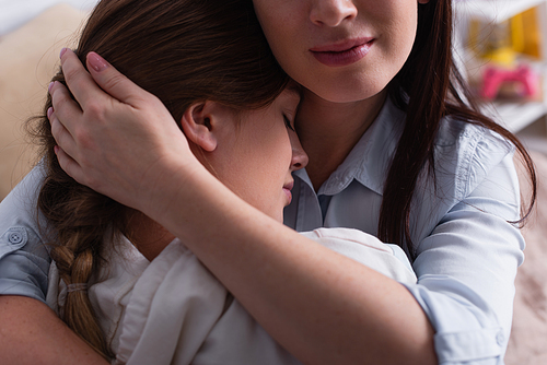 close up of mother hugging teenage daughter