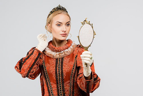 blonde queen in crown looking at mirror isolated on white