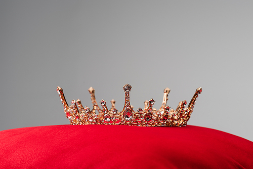 royal crown on red velvet cushion isolated on grey