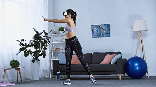 happy young woman in sportswear and vr headset working out at home