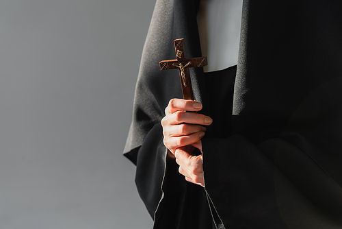cropped view of nun holding crucifix isolated on grey