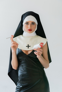 sexy nun  while holding cigarettes isolated on grey