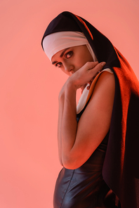 sensual nun  while holding hands near face isolated on pink