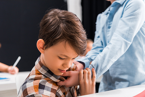 selective focus of cruel schoolkid bullying scared classmate