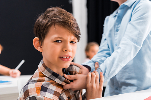 selective focus of cruel schoolkid bullying scared schoolboy