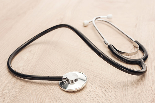 selective focus of stethoscope on wooden and white table