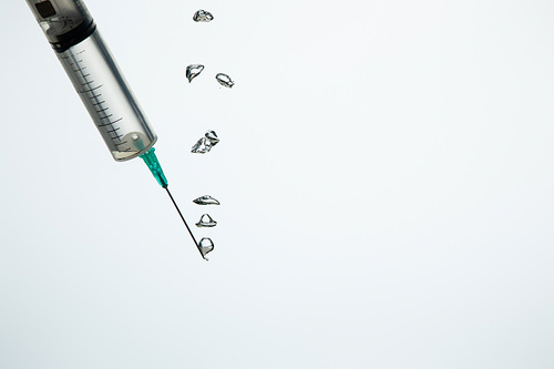 Close up of syringe with bubbles in water isolated on white with copy space