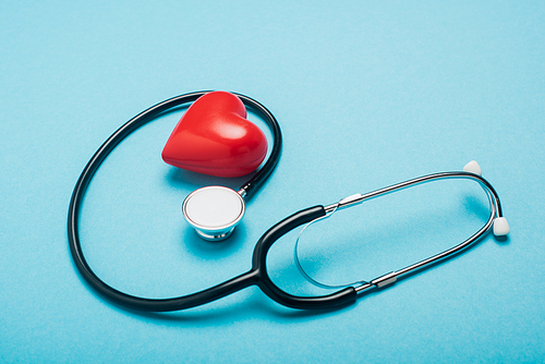 Decorative red heart and stethoscope on blue background, world health day concept