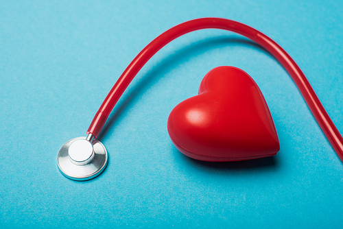 Decorative heart and red stethoscope on blue background, world health day concept