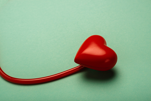 Decorative heart, red stethoscope on green background, world health day concept