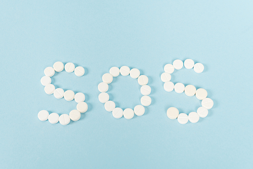 top view of pills with sos lettering on blue