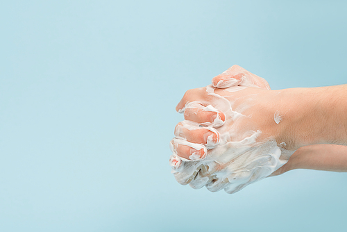 cropped view of man washing hands isolated on blue