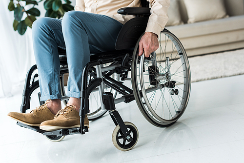 cropped view of disabled senior man sitting in wheelchair at home