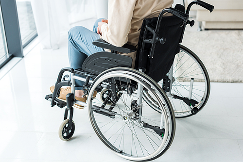 cropped view of disabled retired man sitting in wheelchair at home