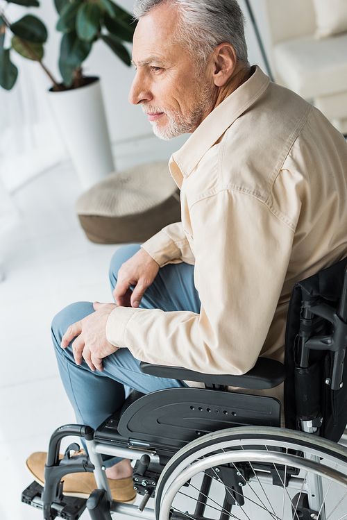 disabled retired man sitting in wheelchair at home