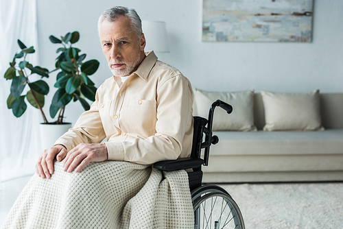 sad disabled retired man sitting in wheelchair and