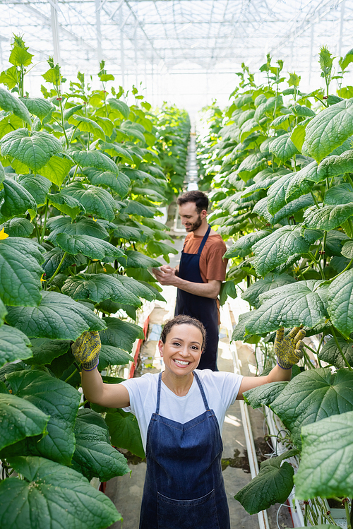 happy african american woman  near colleague working on blurred background