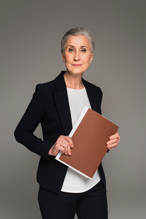 Businesswoman in formal wear holding paper folder isolated on grey