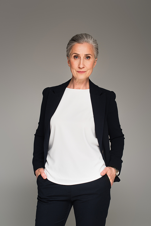 Grey haired businesswoman  isolated on grey