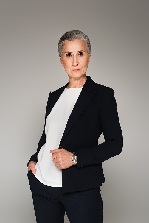 Mature businesswoman in formal wear  isolated on grey