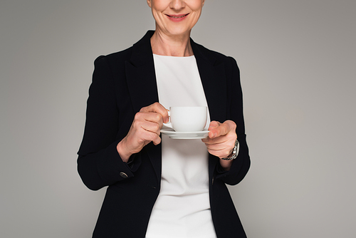 Cropped view of smiling businesswoman holding cup isolated on grey