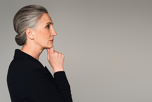 Side view of thoughtful businesswoman isolated on grey