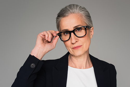 Mature businesswoman in eyeglasses  isolated on grey