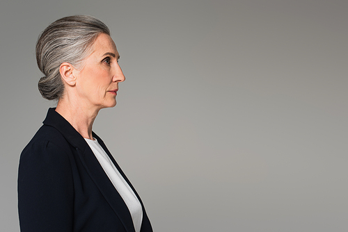 Side view of middle aged businesswoman in formal wear isolated on grey