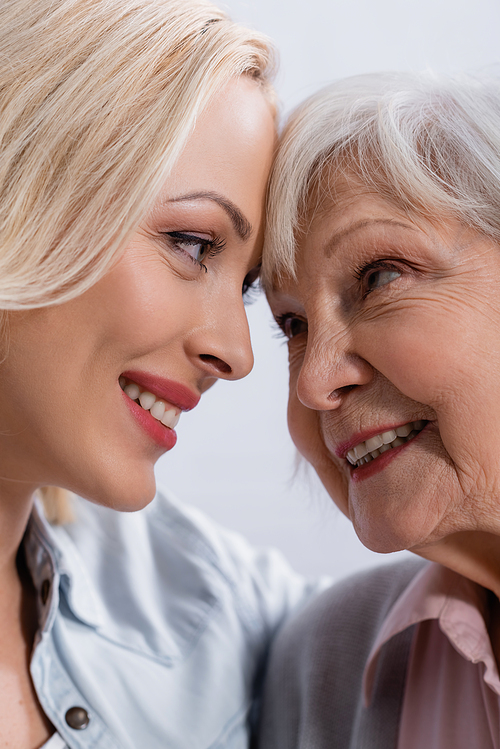 Close up view of smiling woman looking at elderly mother