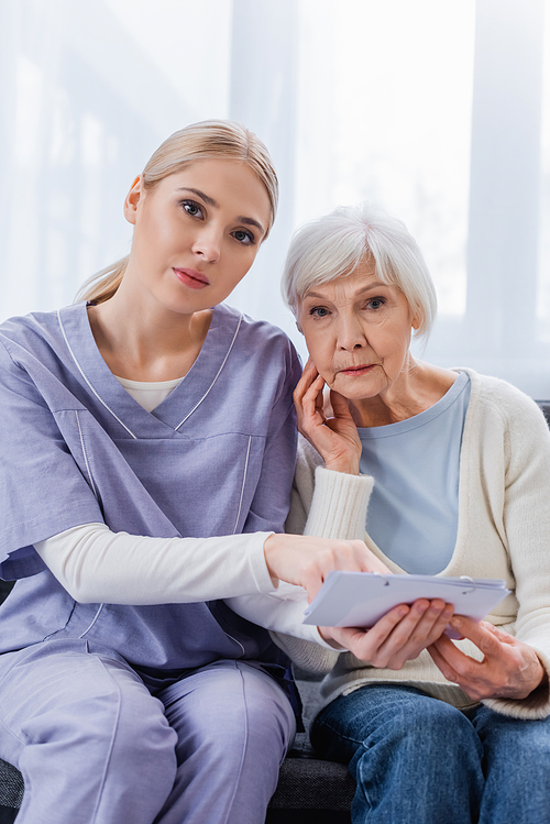young nurse and senior woman, sick on dementia,  while holding calendar
