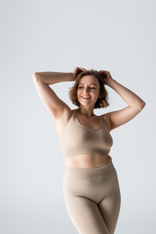 happy overweight young woman in underwear posing isolated on white