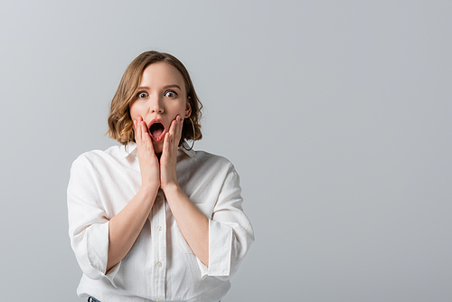 surprised overweight woman in white shirt isolated on grey