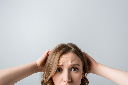 cropped view of worried young woman  isolated on grey