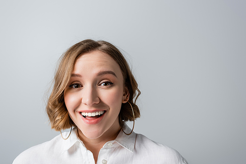 excited overweight woman in white shirt  isolated on grey