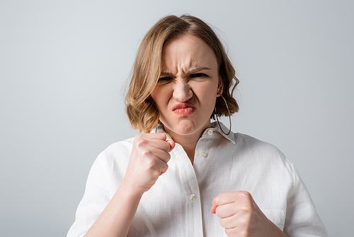 stressed overweight woman in white shirt frowning isolated on grey