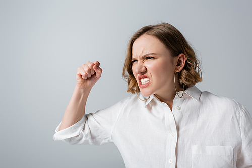 irritated overweight woman in white shirt isolated on grey