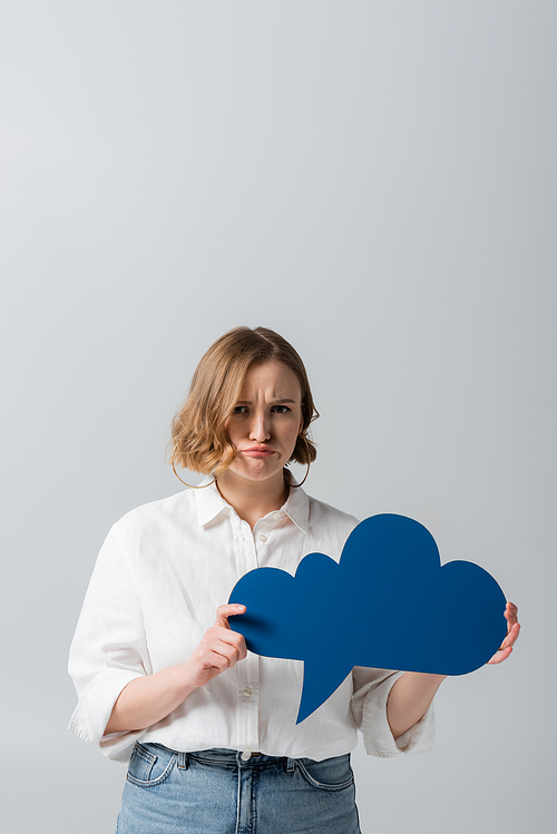 sad overweight woman in white shirt holding blue thought bubble isolated on grey