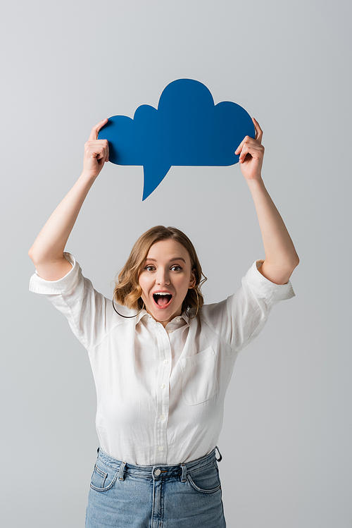 amazed overweight woman in white shirt holding blue thought bubble above head isolated on grey