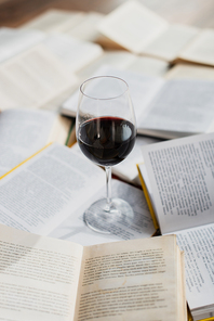 glass of red wine on pile of books