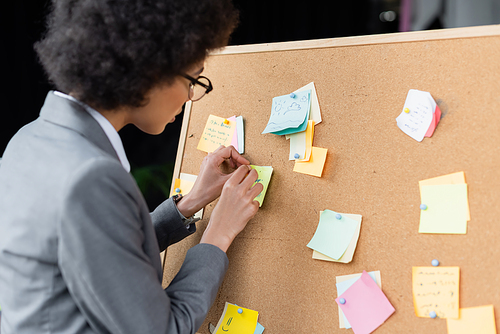 African american businesswoman working with sticky notes in office