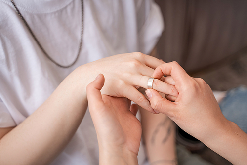 cropped view of woman wearing ring on finger of girlfriend