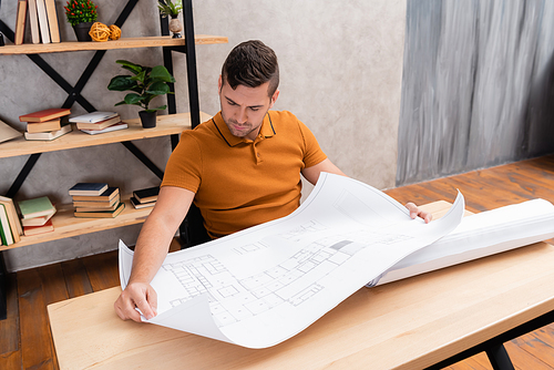 freelance architect looking at blueprint while working at home