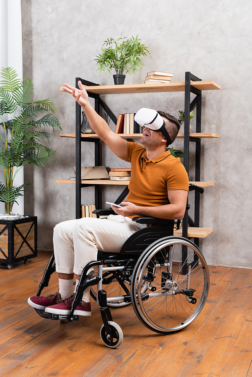 amazed disabled man gesturing while gaming in vr headset at home